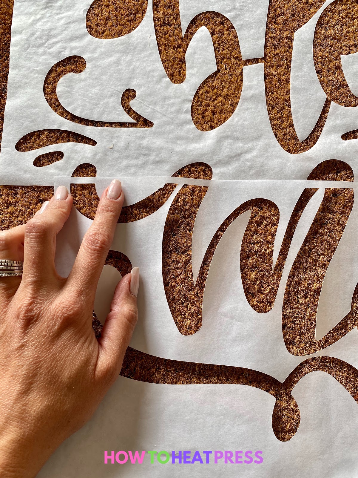 lining up freezer paper stencil on diy doormat