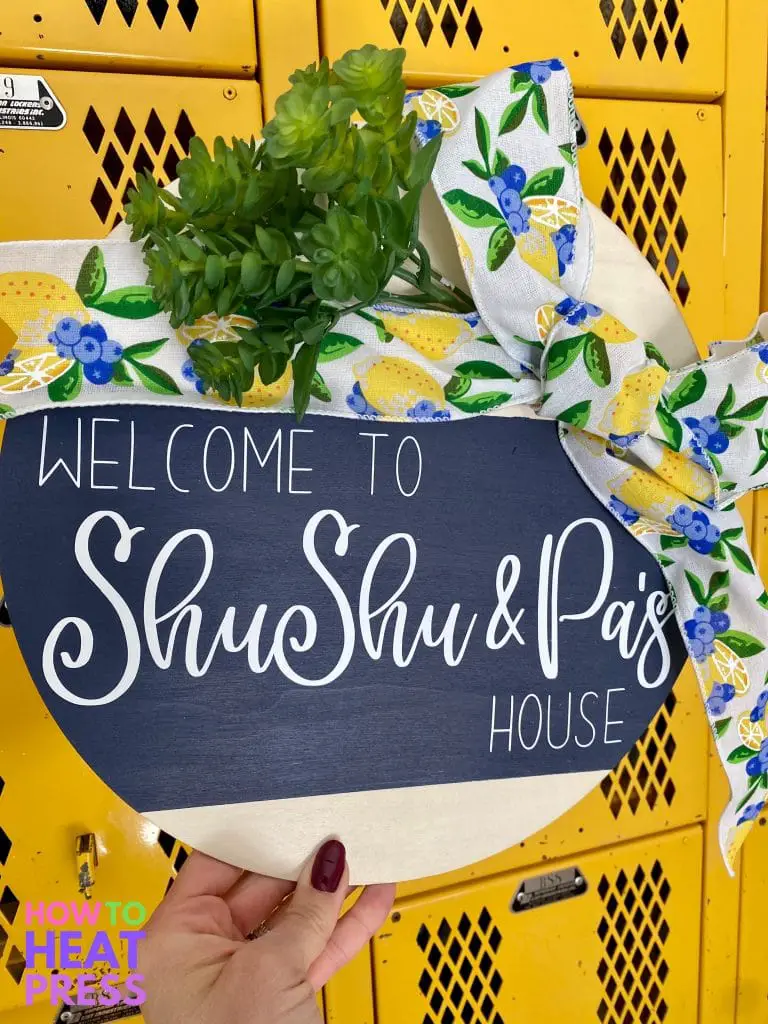 round wood sign with blue background, white letters, lemon and blueberry ribbon, and succulent