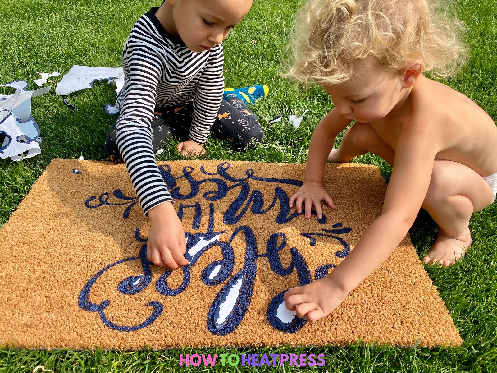 children peeling freezer paper stencil on diy doormat