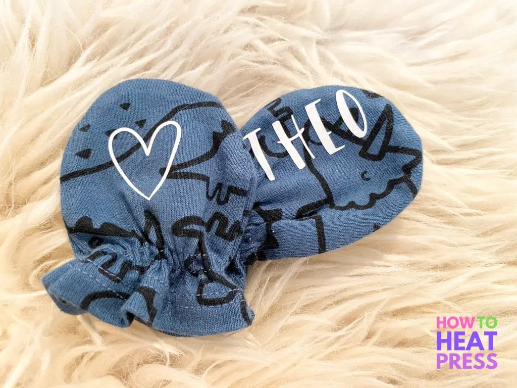 blue baby mittens with black dinosaurs and baby name and heart in white heat transfer vinyl