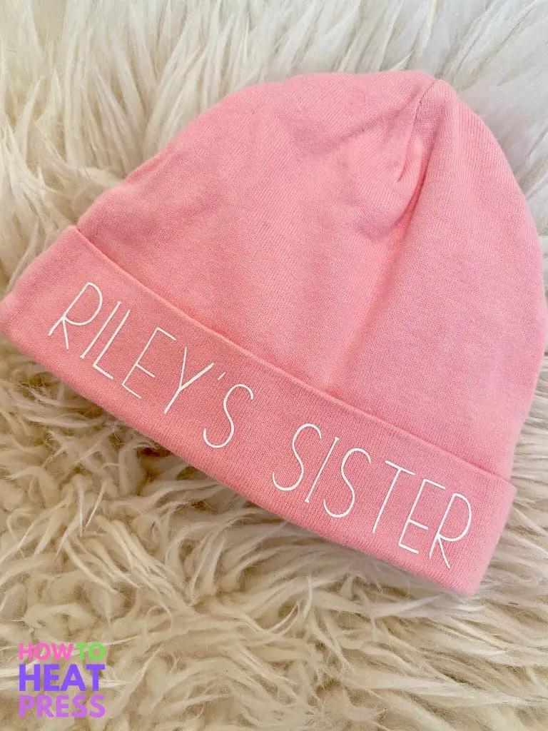 pink baby hat with 'riley's sister' written in white.JPG