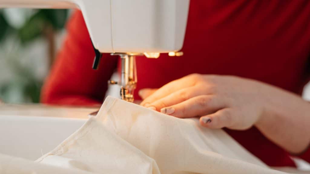 a person's hands using a sewing machine with an led light