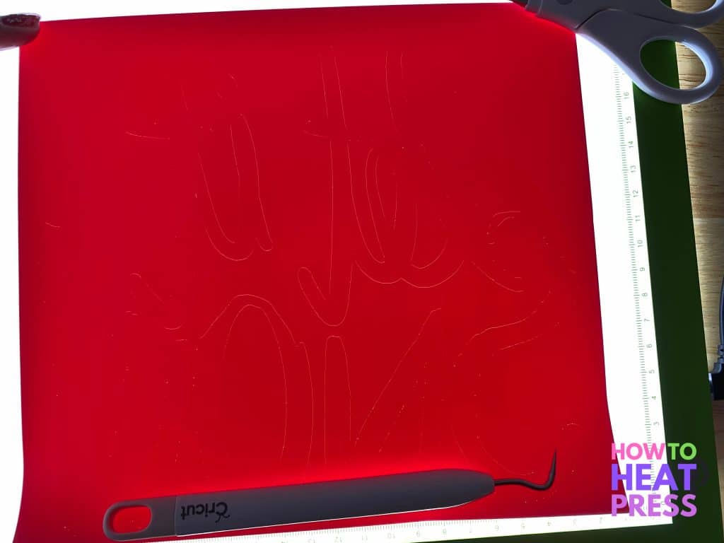 red HTV on light up tracing pad with weeding tools